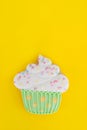 Colorful icing cookie in cupcake shape on yellow background Royalty Free Stock Photo