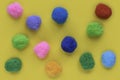 Colorful cotton balls on yellow background Royalty Free Stock Photo