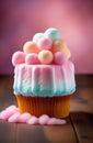 Colorful cotton candy cake cupcake with fluffy balls on top on wooden surface against pink background. Royalty Free Stock Photo