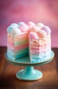 Colorful cotton candy cake with fluffy balls on top on teal-colored stand on wooden surface against pink background. Royalty Free Stock Photo