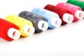 Sewing threads of different colors on reels on a white background. Free space, close-up. Isolate Royalty Free Stock Photo