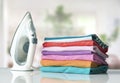 Colorful cotton shirts folded stack on table with iron. Household concept. Spring summer clothes Royalty Free Stock Photo
