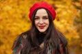 Colorful, cozy autumn, fashion concept. Outdoor portrait of young beautiful smiling girl wearing red beret. Model wrapped in