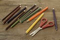 Colorful crayons, pencils and scissors on wooden background Royalty Free Stock Photo