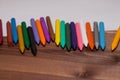 Colorful crayons with a white blank sheet of paper on a wooden b