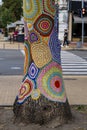 Colorful crochet knit on tree trunk in Kyiv, Ukraine. Street art goes by different names, graffiti knitting, yarn bombing. Royalty Free Stock Photo