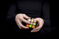 Colorful cube in the hands of a man in black clothes Royalty Free Stock Photo