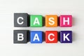 Colorful cubes with word Cashback on white wooden table, flat lay