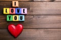 Colorful cubes with words I Love You and red heart on wooden background, flat lay. Space for text Royalty Free Stock Photo