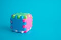 Colorful cubic assembly toy on blue background copy space. Royalty Free Stock Photo