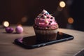 Colorful cupcake sitting on top of a smartphone Royalty Free Stock Photo