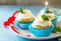 Colorful cupcake with whipped cream, poppy and orange peel on a blue a stone or slate background Royalty Free Stock Photo