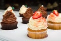 Colorful cupcakes with different Tastes. Small beautifull chocolate and strawberry cupcakes on white Shop-window.