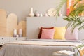 Colorful cushions on bed with headboard next to cabinet in grey Royalty Free Stock Photo