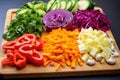 colorful cut vegetables on a wooden chopping board Royalty Free Stock Photo