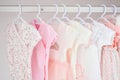 Colorful, cute girl baby dresses hanging on rack in wardrobe. Baby fashion concept design. Royalty Free Stock Photo