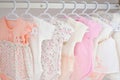 Colorful, cute girl baby dresses hanging on rack in wardrobe. Baby fashion concept design. Royalty Free Stock Photo