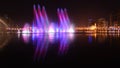 Colorful dancing fountain with mosque in the city at night with lively music