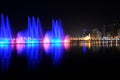 Colorful dancing fountain with mosque in the city at night with lively music