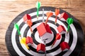 Colorful Dart Arrows Hitting House Model And Dartboard Royalty Free Stock Photo