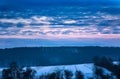 Colorful dawn sunrise in winter over hills forests countryside