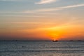 Colorful dawn, sunset on a calm sea. Silhouette of a fishing boat on the horizon.  Beautiful sea background, landscape. Fiery Royalty Free Stock Photo