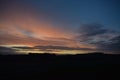 colorful dawning day sky above a dark hill