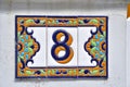 A colorful decorated ceramic house number plaque, showing the number eight Royalty Free Stock Photo