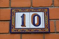 A colorful decorated ceramic house number plaque, showing the number ten Royalty Free Stock Photo