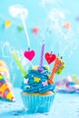 Colorful decorated cupcake with candles blow up