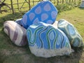 Colorful decorated stone just for show or decorum on green field.