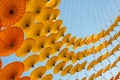 Colorful decoration set with hung upside down orange and yellow umbrellas, with the blue sky as background, in Vietnam