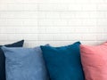 Colorful decorative resting pillow on sofa in front of white brick background. Royalty Free Stock Photo