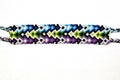 Colorful designer unique friendship bracelet handmade of threads with bright pattern isolated on white background