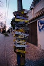 Colorful directions signs on the Old Town Zemun to different places of the world. A pedestrian street with cobblestones