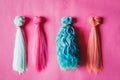 Colorful dolls hair on pink background