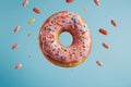 Colorful donut with pink icing and sprinkles. Macro view of sweet american dessert isolated on blue background. Royalty Free Stock Photo