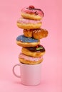 Colorful donuts breakfast composition with different color styles of donuts and fresh coffee on pink background Royalty Free Stock Photo