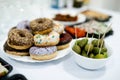 Colorful donuts with icing and green olives on the table
