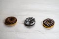 Colorful donuts on white wooden table. Sweet icing sugar food with glazed sprinkles, doughnut with frosting. Top view with copy Royalty Free Stock Photo