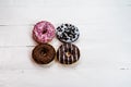 Colorful donuts on white wooden table. Sweet icing sugar food with glazed sprinkles, doughnut with frosting. Top view with copy Royalty Free Stock Photo