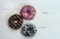 Colorful donuts on white wooden table. Sweet icing sugar food with glazed sprinkles  doughnut with frosting. Top view with copy Royalty Free Stock Photo