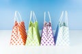 Colorful dotted shopping bags on blue background