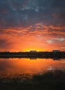 Colorful and dramatic sunset sky reflecting on pond water. Silent evening scene at Delia lake. Vibrant sundown clouds at the Royalty Free Stock Photo