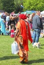 Orange dressed Muslim woman is shopping at the flea market (vrijmarkt), Kingsday in Holland