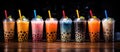 Colorful drinks with tapioca bubbles in transparent cups on a black background