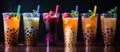 Colorful drinks with tapioca bubbles in transparent cups on a black background