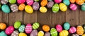 Colorful Easter banner with double border of Easter Eggs over a dark wood background with copy space Royalty Free Stock Photo