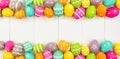 Colorful Easter banner with double border of Easter Eggs over a white wood background with copy space Royalty Free Stock Photo