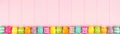 Colorful Easter banner with a row border of Easter Eggs over a pink wood background with copy space Royalty Free Stock Photo